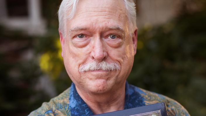 Chris Camp holds a photo album with the words Chris & Jack on the cover