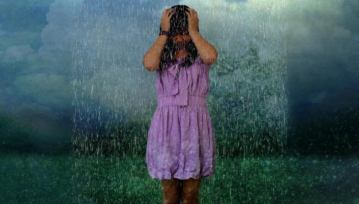 a teenage girl in a purple dress under a rain cloud