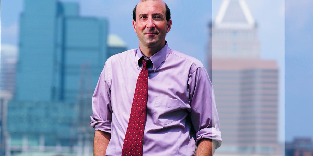 Peter Beilenson with Baltimore's Inner Harbor behind him