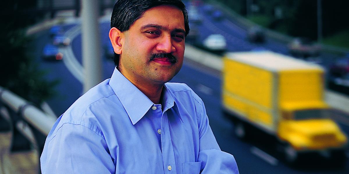 Adnan Hyder stands on a bridge with a highway behind him