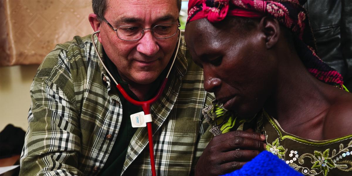 Philip Thuma listens to a man's lungs with a stethoscope