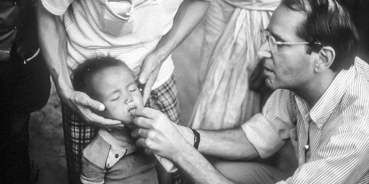 Al Sommer administers the contents of a vitamin A capsule in Nepal’s national vitamin A distribution campaign, c. 1985.