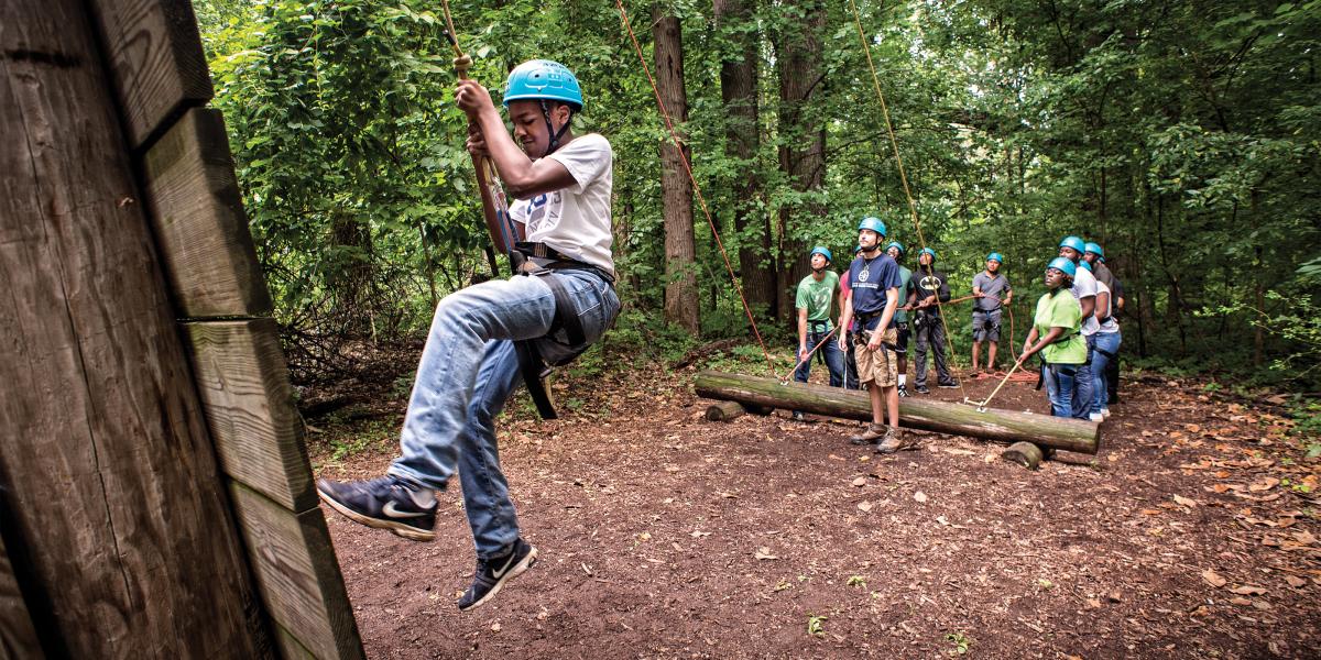 A child climbs on a ropes course during the police-youth program at the Baltimore Chesapeake Bay Outward Bound School.