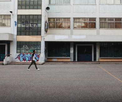 Image of refugees playing cricket in an abandoned school yard