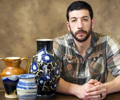 Adrian Weiss poses with some of his pottery.