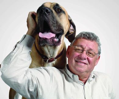 Allen Goldberg pets a big dog with its tongue out