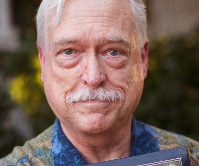 Chris Camp holds a photo album with the words Chris & Jack on the cover