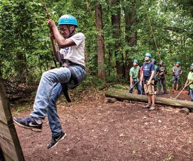 A child climbs on a ropes course during the police-youth program at the Baltimore Chesapeake Bay Outward Bound School.