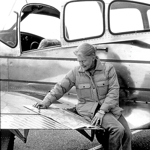 Sue Baker sitting on wing of plane